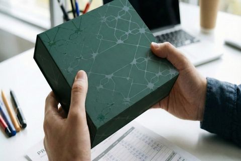 Khách hàng kiểm tra hộp giấy mẫu in thử trong quy trình tư vấn in theo ngân sách.