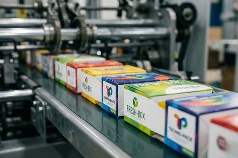 Thành phẩm vỏ hộp sắc nét trên băng chuyền gia công tự động của xưởng in hộp giấy.