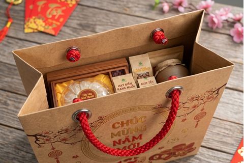 Hệ thống nẹp miệng gia cố và khuy mắt cáo kim loại bảo vệ quai xách của túi giấy chúc mừng năm mới đựng quà tết trọng lượng lớn.