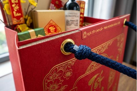 Hệ thống quai xách gia cố khuy mắt cáo chắc chắn của túi xách giấy đựng quà tặng.