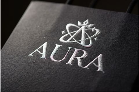 Hiệu ứng ép kim và dập nổi logo trên nền giấy làm túi xách.