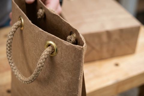 Hệ thống nẹp miệng và khuy mắt cáo kim loại bền bỉ được tích hợp trong quy trình làm túi giấy chịu tải cho nông sản.