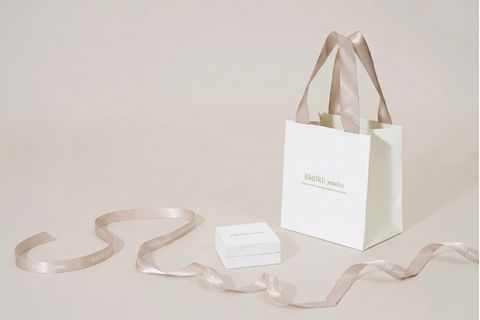 Cận cảnh bề mặt giấy mỹ thuật vân sần phối hợp cùng quai xách lụa gân của mẫu túi giấy dây ruy băng đẳng cấp.