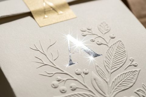 Chi tiết logo ép kim và dập nổi cơ học trên bề mặt túi giấy không quai giúp tăng nhận diện thương hiệu.