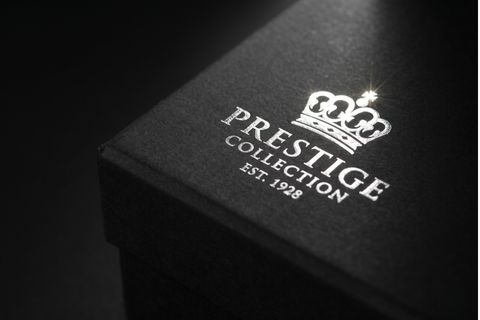 Logo thương hiệu được ép kim bạc lấp lánh trên bề mặt in hộp giấy đựng quần áo.