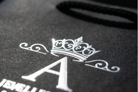 Logo thương hiệu được ép kim bạc rực rỡ trên bề mặt in túi giấy cho shop thời trang.