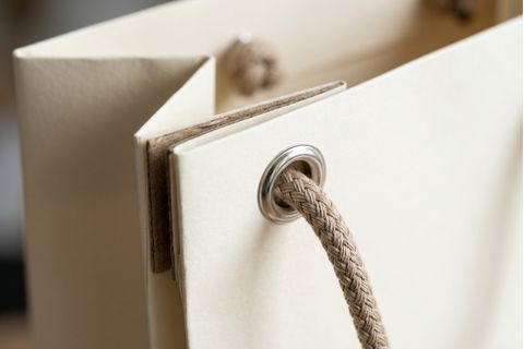 Chi tiết nẹp miệng gia cố và khuy mắt cáo kim loại trong kỹ thuật in túi giấy có quai chịu tải trọng lớn.