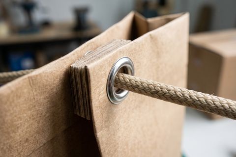 Chi tiết khuy mắt cáo và nẹp miệng gia cố siêu dày bảo vệ hệ thống chịu tải khi in túi giấy cỡ lớn gánh hàng nặng.